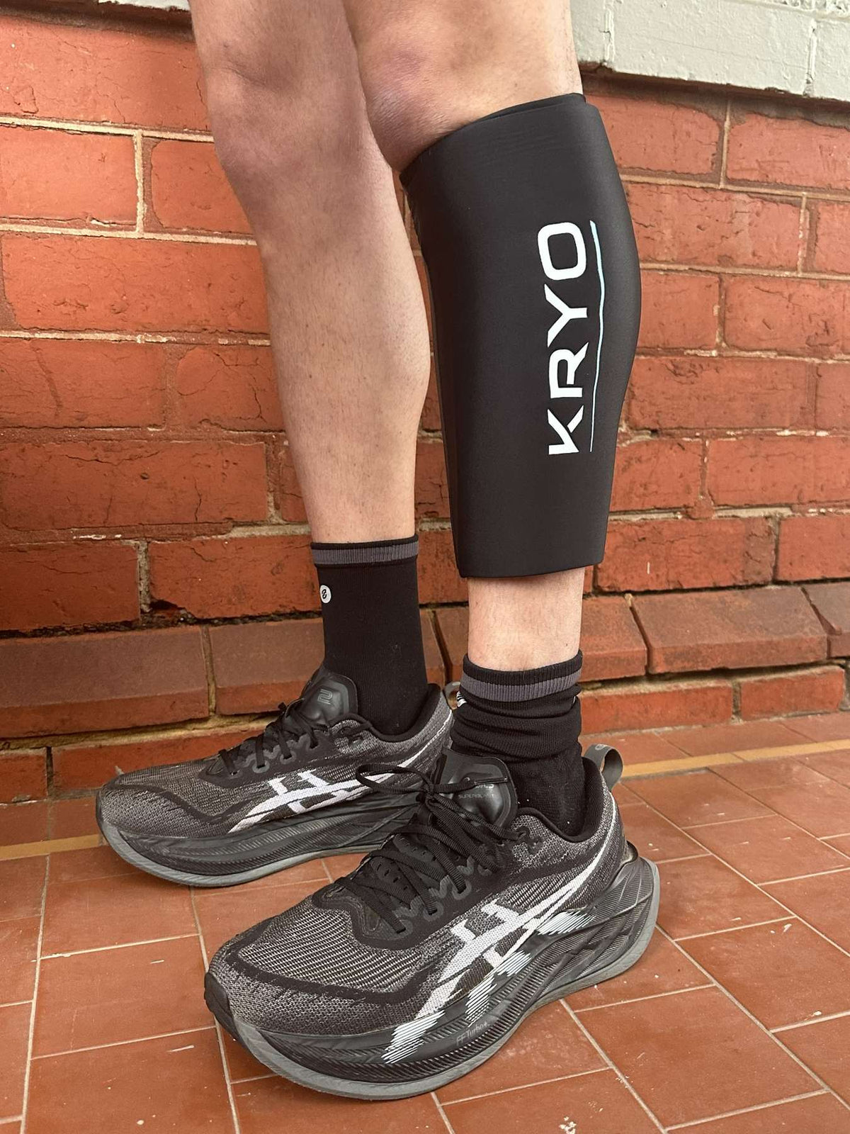 Runner wearing KRYO CORE calf ice compression sleeve for post-run recovery
