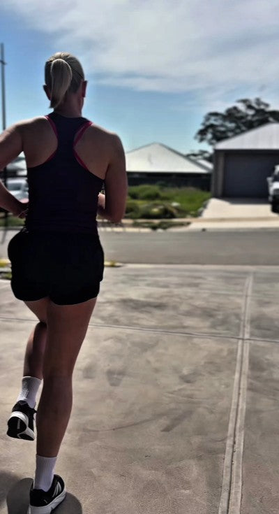 Woman wearing a KRYO CORE cold compression sleeve on her knee after running for targeted recovery.