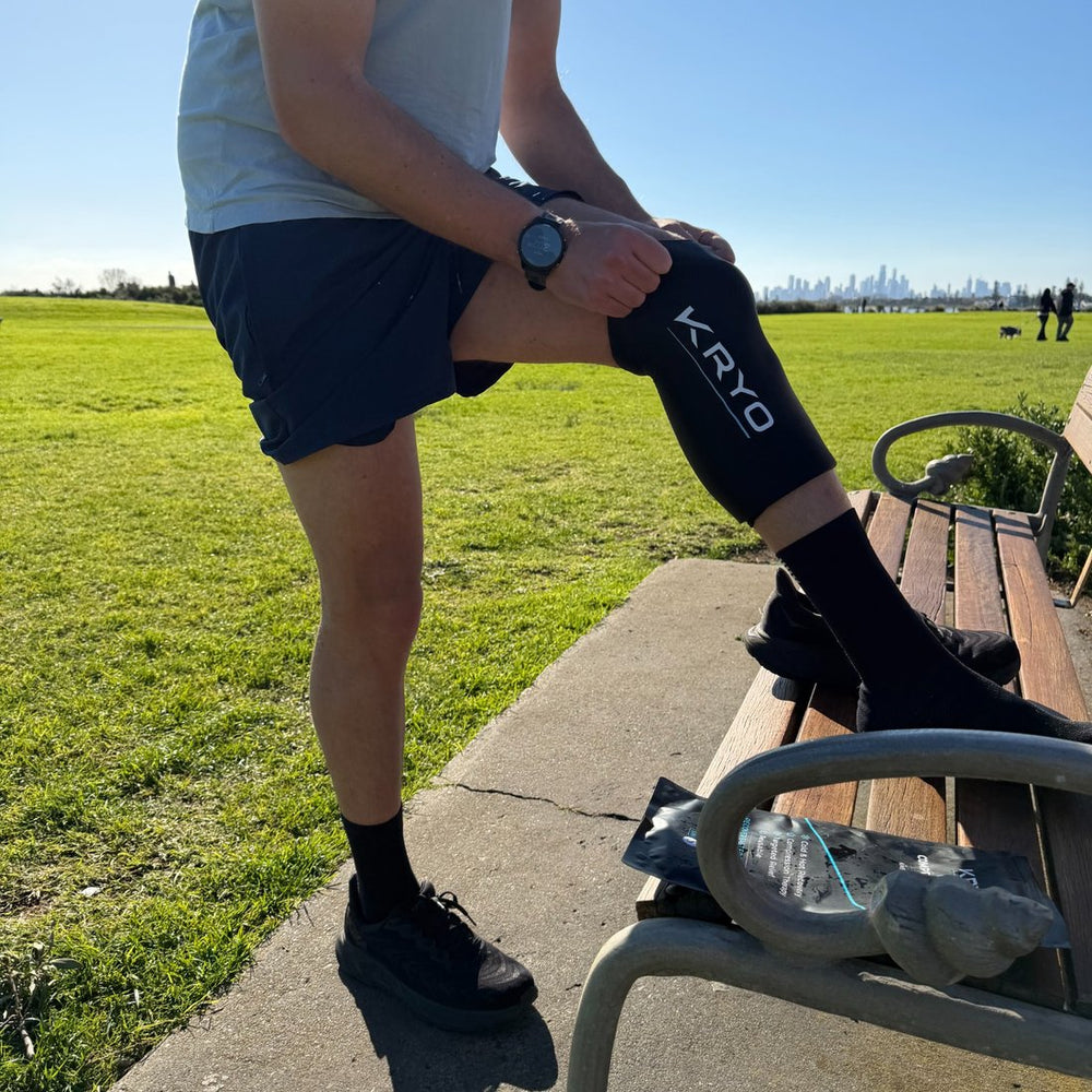 Man wearing a KRYO CORE cold compression sleeve on his knee after a run outdoors.