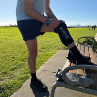 Man wearing a KRYO CORE cold compression sleeve on his knee after a run outdoors.