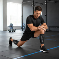 Man in a gym wearing two KRYO CORE ice compression sleeves, one on each calf, from the Performance Kit