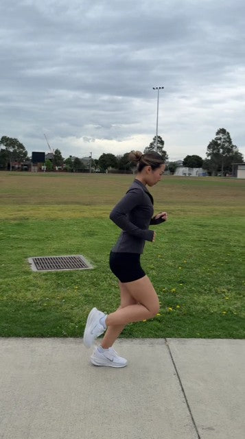 Female runner relaxing after training while wearing the KRYO MAX hot and cold compression sleeve on her thigh. 