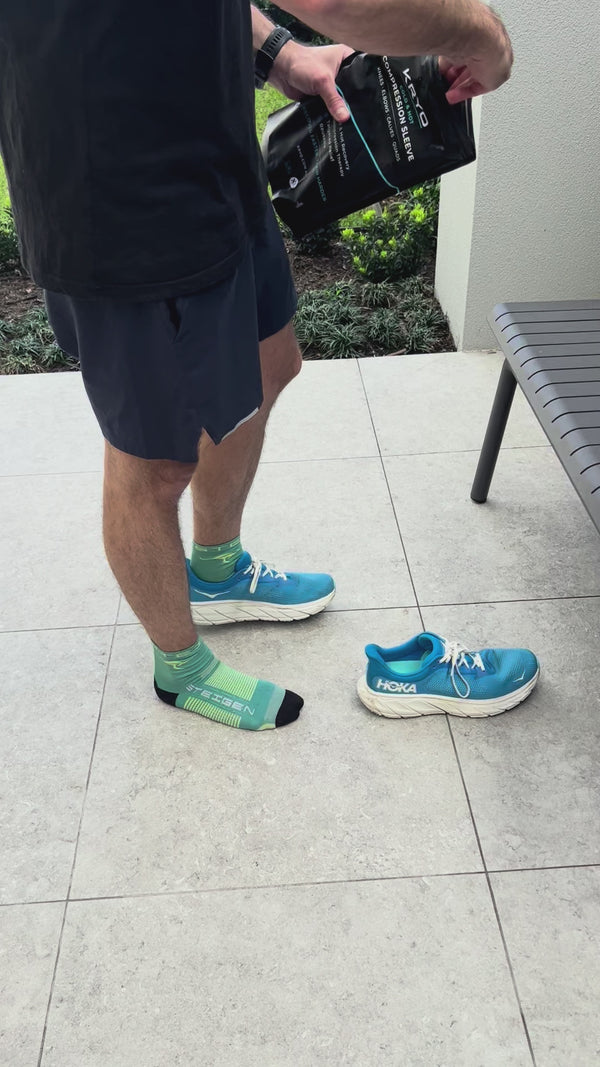 KRYO MAX ice compression sleeve being fitted on the thigh outdoors for post-run recovery